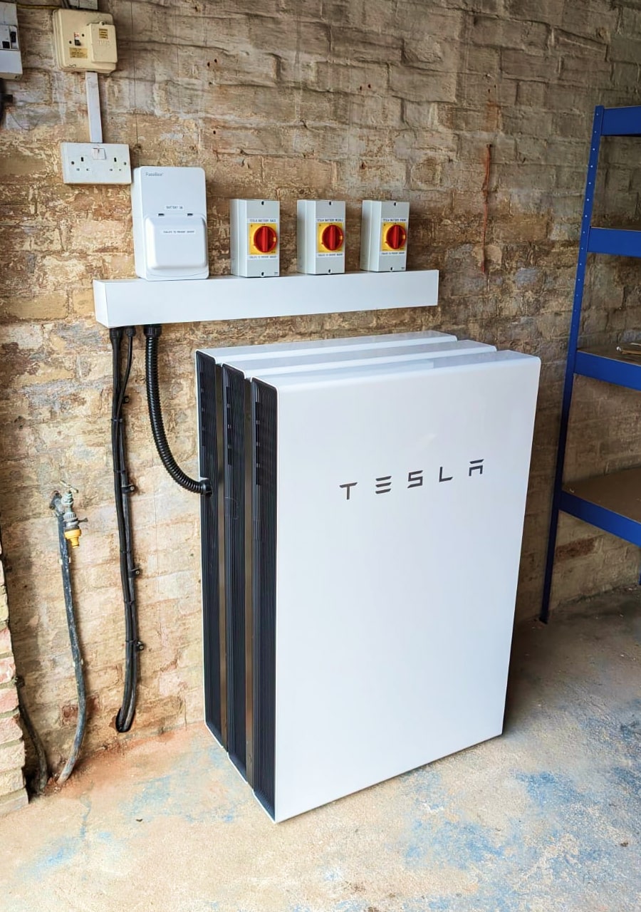 Three stacked Tesla Powerwall battery units with 40.5kWh storage
                capacity in garage