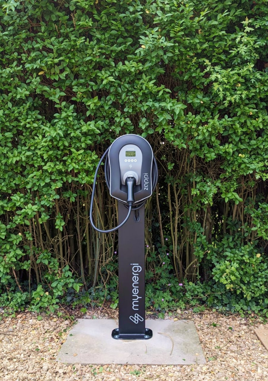 Black tethered myenergi zappi EV charger on pedestal with an
                8.4kW array and Tesla Powerwall battery